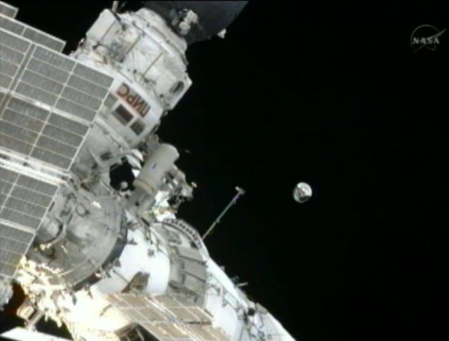 Spacewalking cosmonauts heave a 20-pound metal ball into Earth orbit