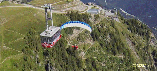 Paraglider flies so close to cable car that he can high five passengers