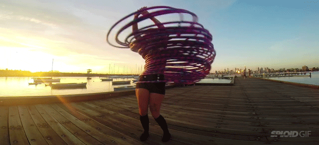 Girl dancing with 30 hula hoops looks like she's about to get teleported