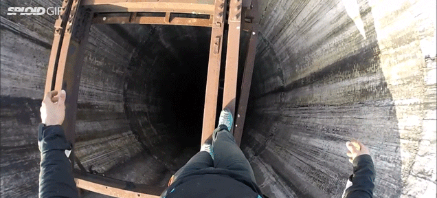 Daredevil walks on a narrow beam over a 900-foot tall giant hole