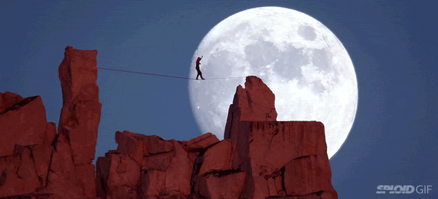 Guy walking on a tight rope against a stunningly beautiful moon