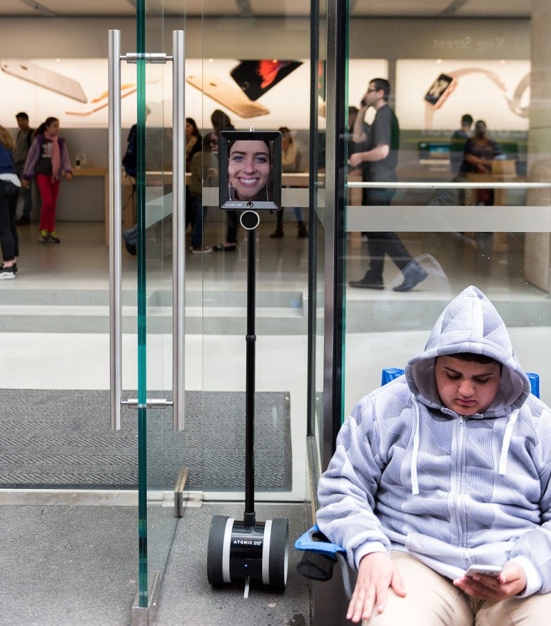 Una mujer hace cola para comprar el iPhone 6s mediante un robot de telepresencia