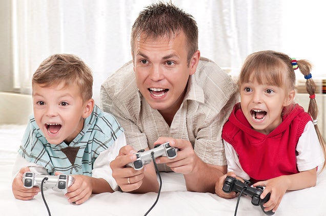 A Dad And His Kids Happily Play Video Games Together. They Have To.