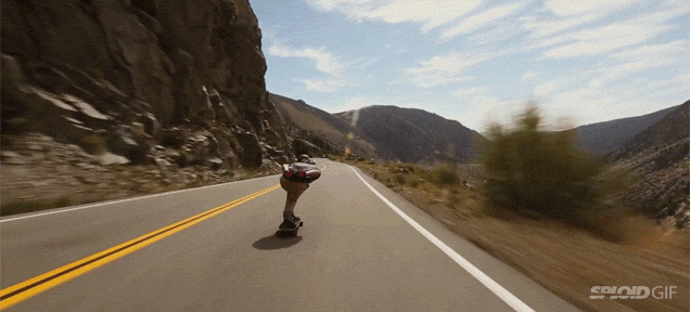 Skateboarder zips down mountains and flys by cars at insane speeds