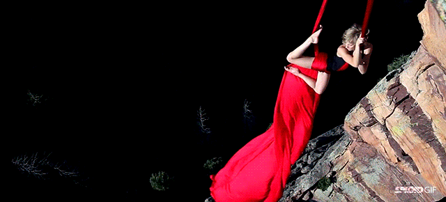 Woman risks life dancing over a cliff entangled in fabric