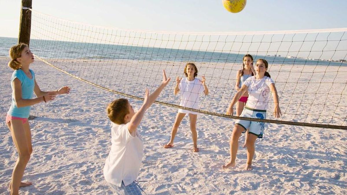 дети играют в волейбол на пляже