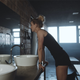 woman in a gym locker room looking into the mirror