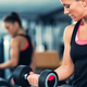 woman doing a bicep curl by a mirror