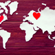 A cut-out of the continents with a red heart in the U.S. and one in Europe