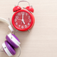 An alarm clock next to a pair of headphones