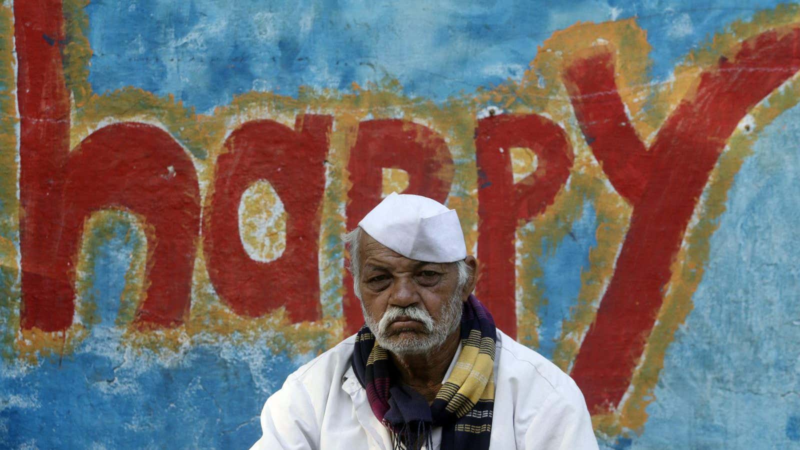 A farmer sits next to graffiti at the end of a six-day long march on foot, in Mumbai, March 12, 2018.