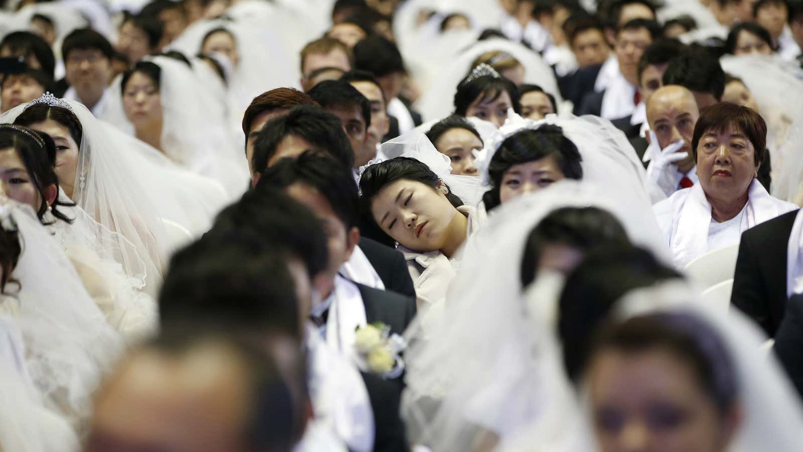 A bride naps during a mass wedding ceremony of the Unification Church at Cheongshim Peace World Centre in Gapyeong, March 3, 2015. The Unification Church…