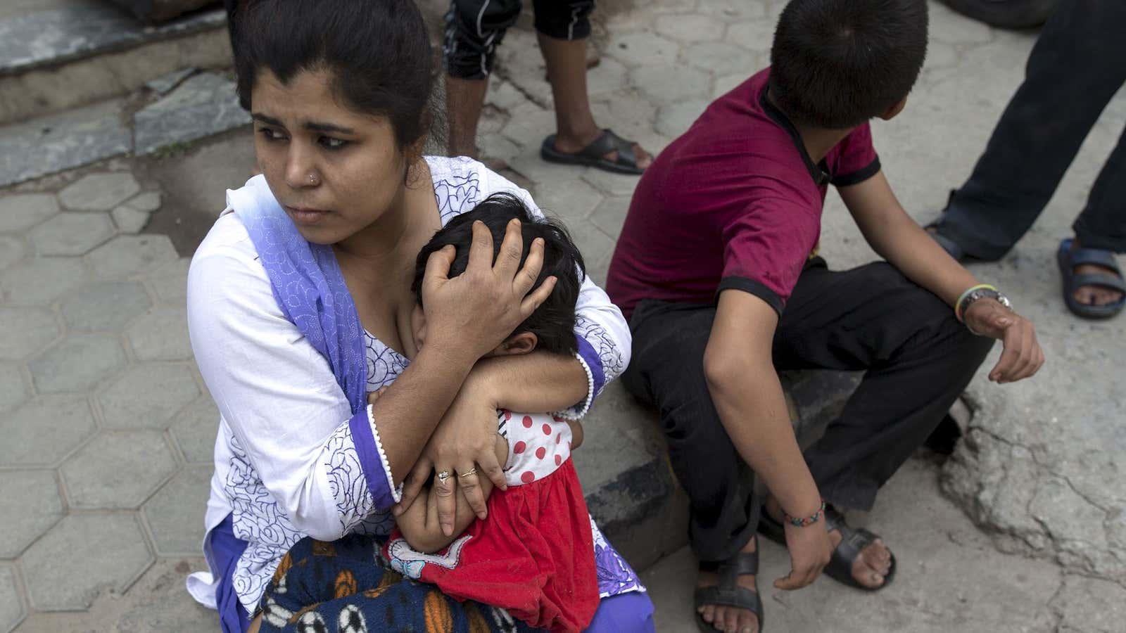 A Nepalese woman holds her daughter minutes after a second earthquake.