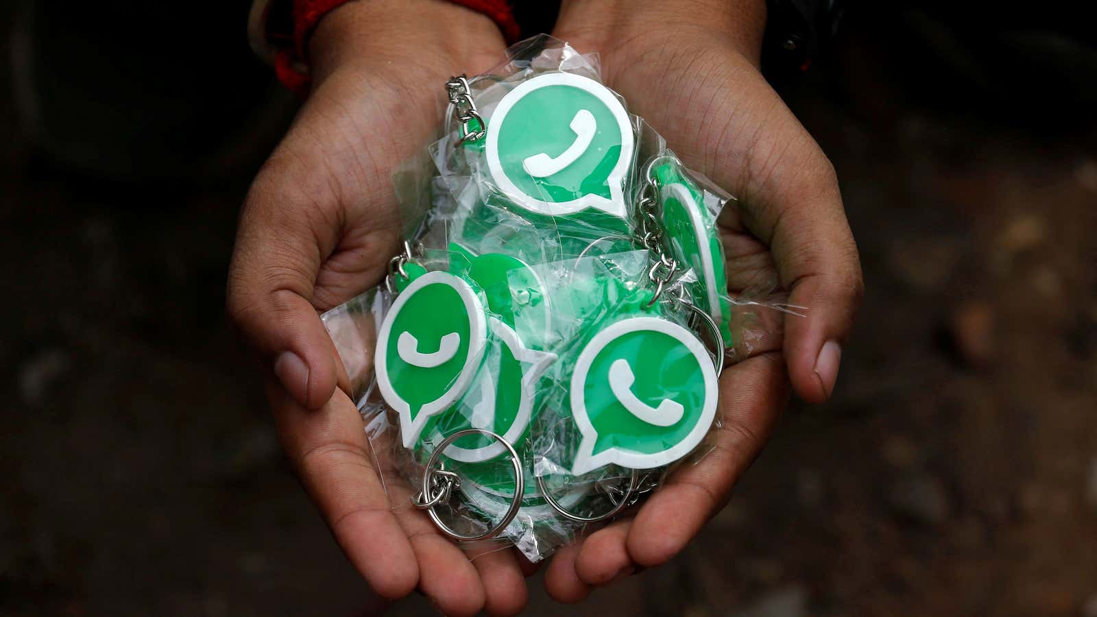 A WhatsApp-Reliance Jio representative displays key chains with the logo of WhatsApp for distribution during a drive by the two companies to educate users, on…