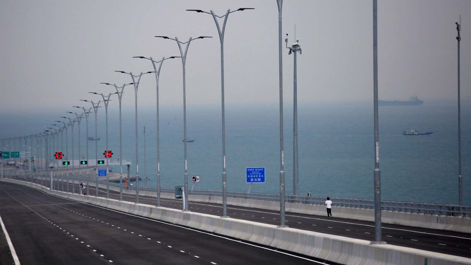 A journalist runs on the Hong Kong side of the Hong Kong-Zhuhai-Macau bridge October 19, 2018, days before its opening ceremony. REUTERS/Bobby Yip – RC1499661C70