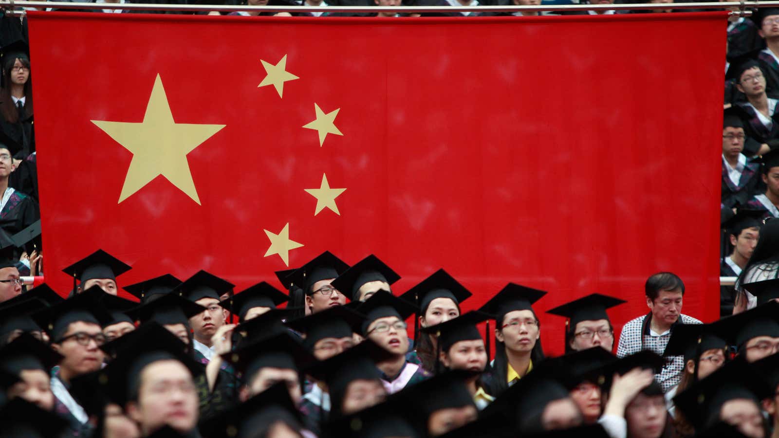 Graduates set next to the Chinese flag during a graduation ceremony at Fudan University in Shanghai June 28, 2013. A record high of 6.99 million…
