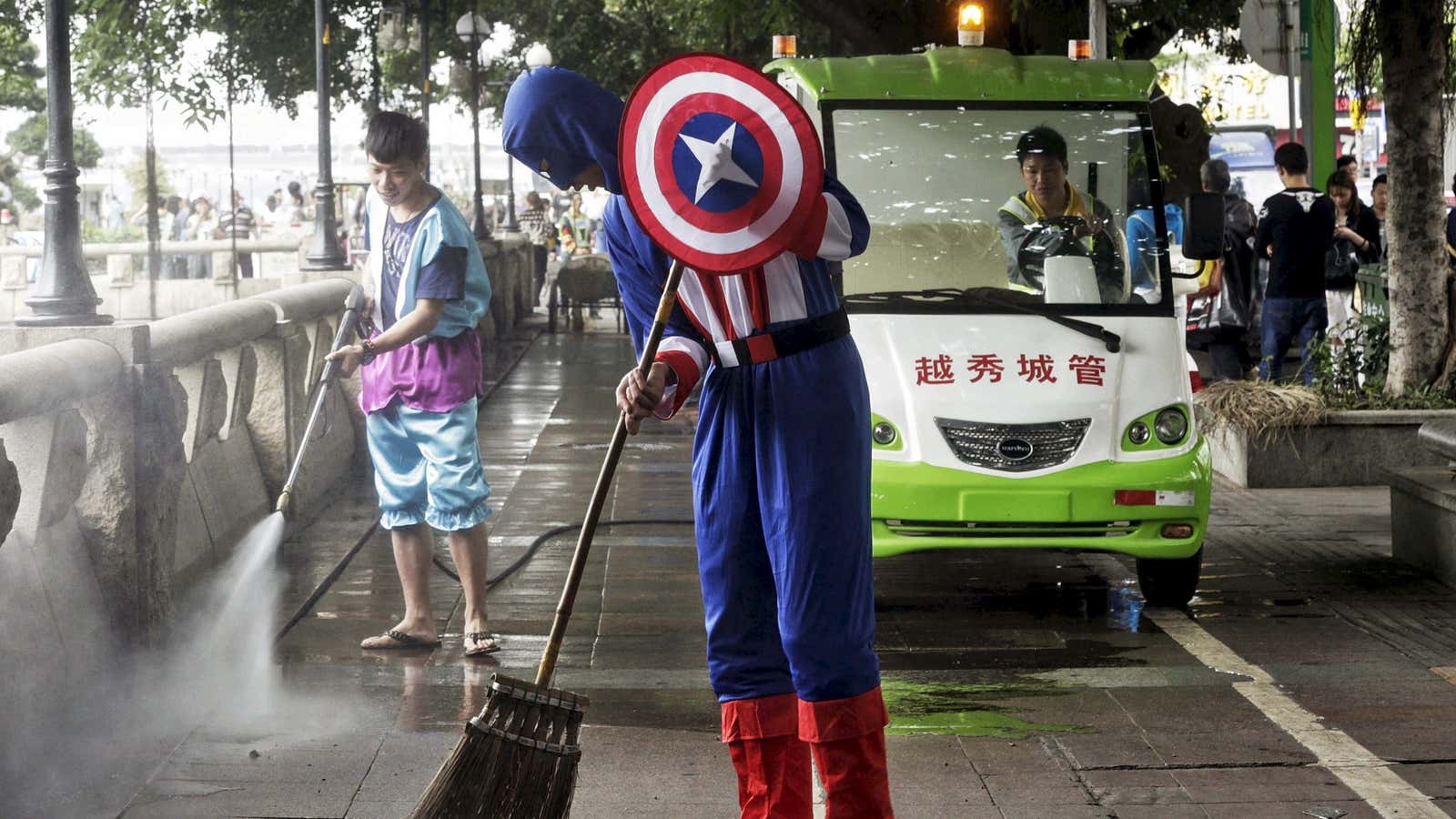 A student dressed as Captain America sweeping a street in Guangzhou.
