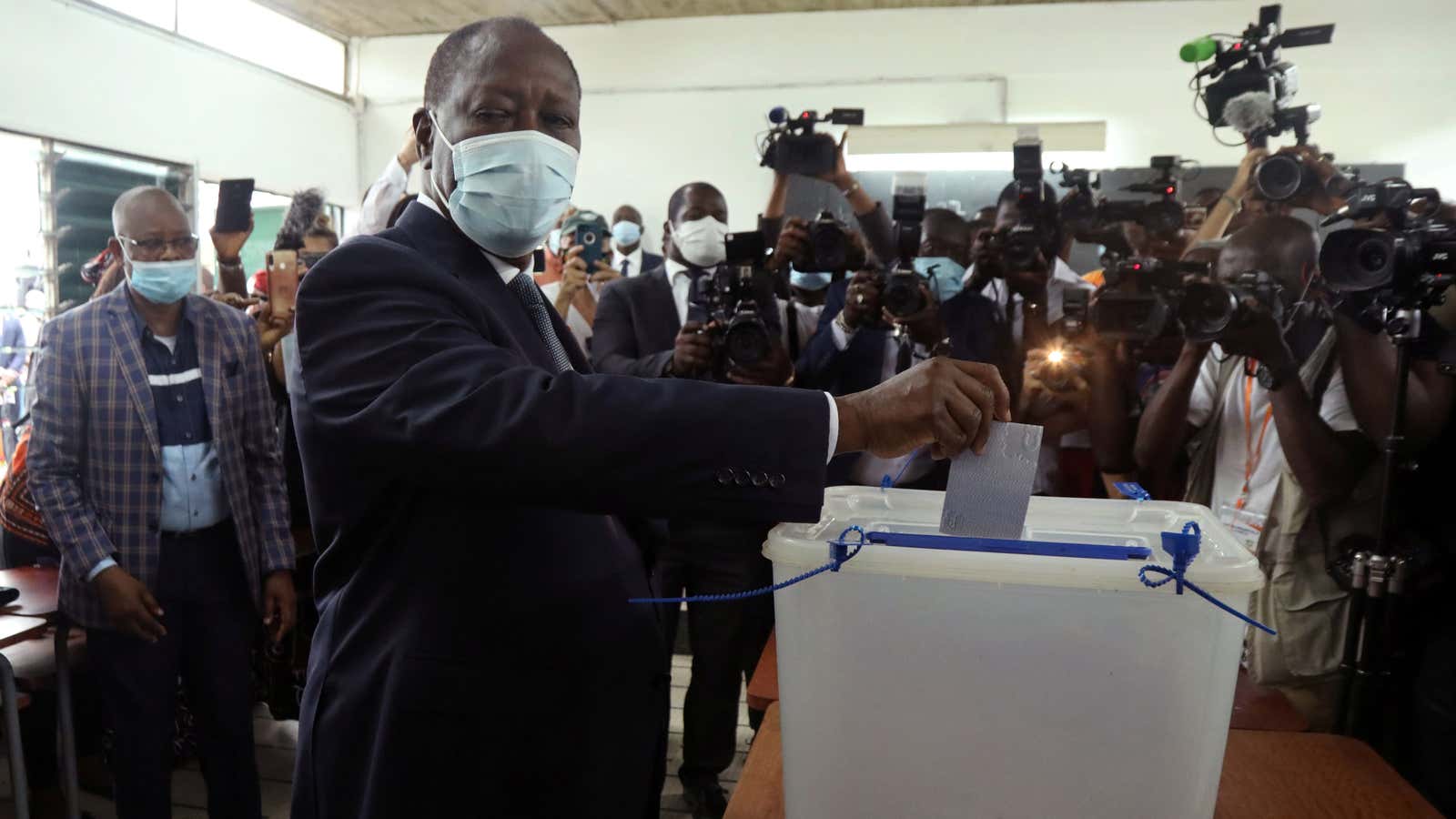Ivorian president Alassane Ouattara wearing a face mask casts his vote in Abidjan, Ivory Coast Oct. 31, 2020.