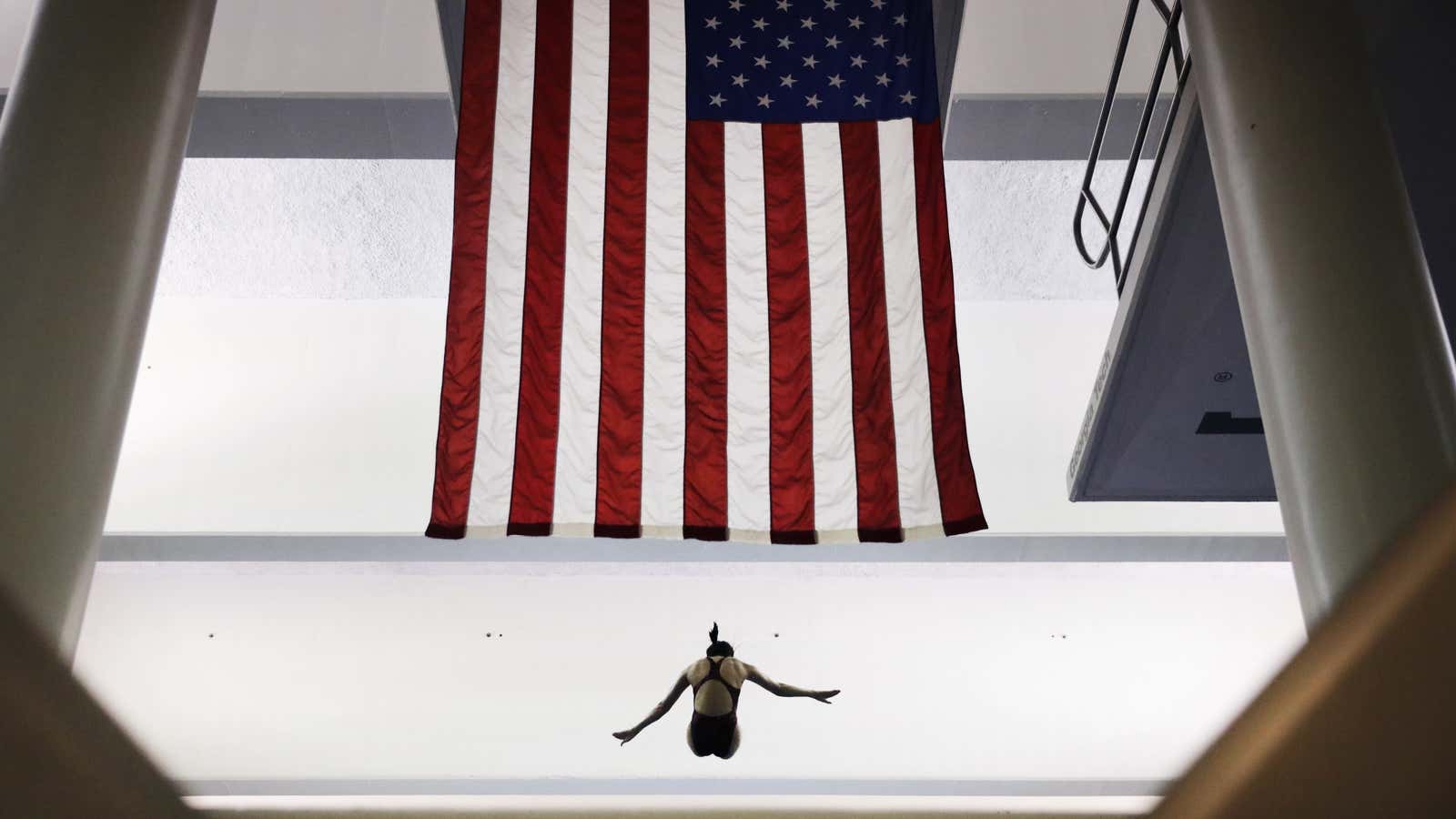 Harvard’s Jing Leung descends past a United States flag during the platform diving at the NCAA women’s swimming and diving championships at Georgia Tech Saturday, March 19, 2016, in Atlanta. (AP Photo/David Goldman)