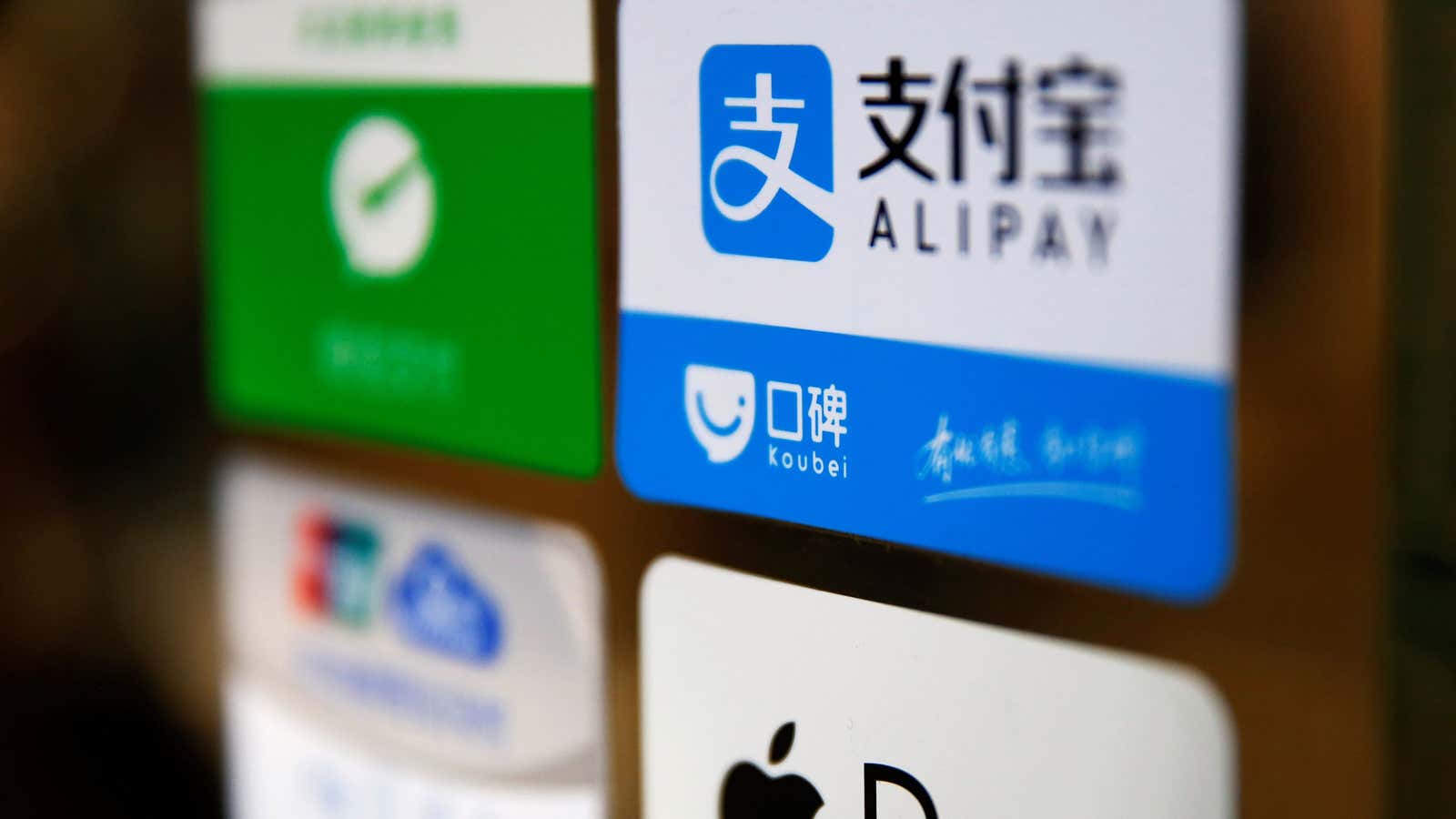 An Alipay logo is seen among other paying method stickers on the doors of a restaurant at the Beijing Railway Station in central Beijing January…