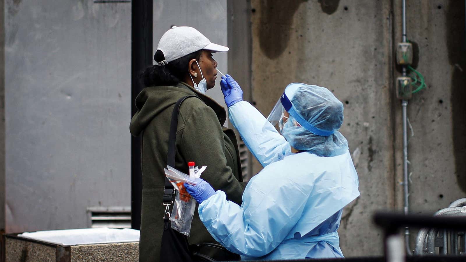 A patient is given a COVID-19 test by a medical worker outside Brooklyn Hospital Center, Sunday, March 29, 2020, in Brooklyn borough of New York.