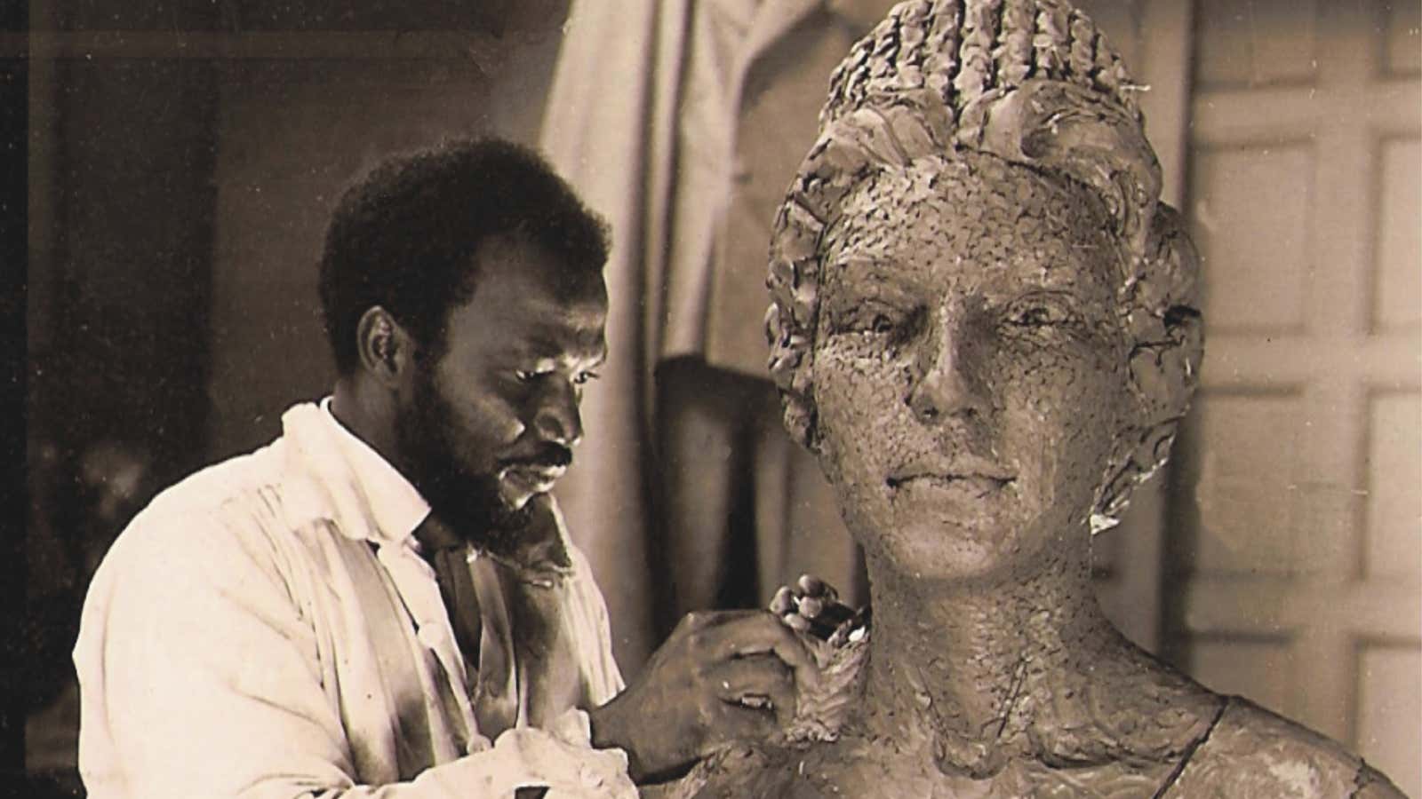 Archival picture of Ben Enwonwu in the studio of Sir William Reid- Dick, working on bronze portrait of Queen Elizabeth II.