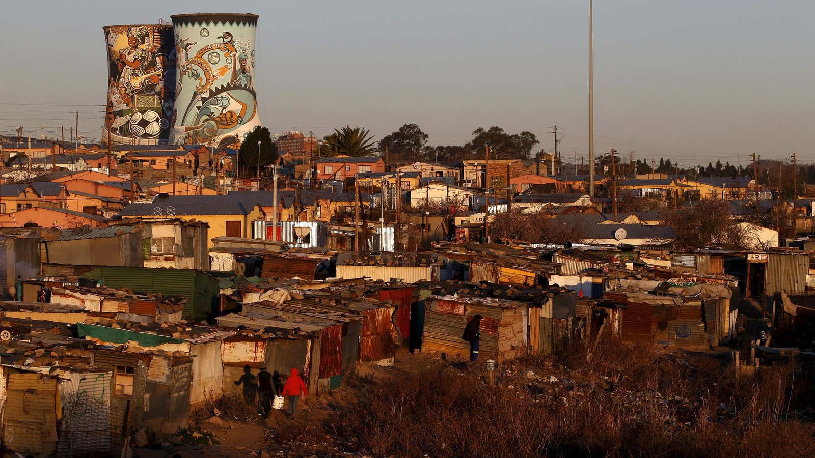 Unused cooling towers are seen overlooking an informal settlement in Soweto, South Africa