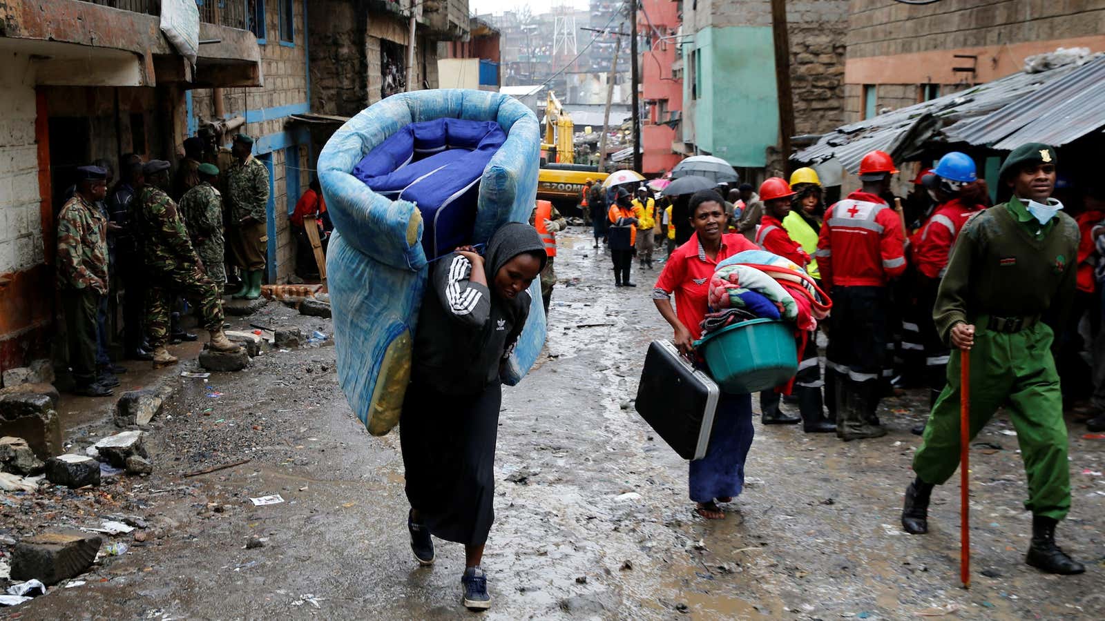 People carry their belongings as they leave the Huruma neighborhood after a a six-story building collapsed during heavy rains.