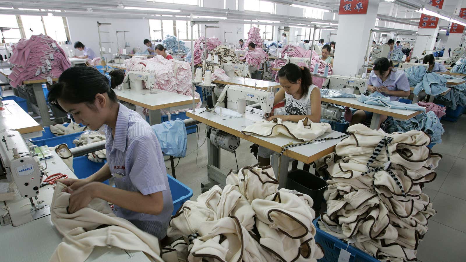 Labourers work on garments for export at the production line of a garment factory in Shanghai August 27, 2007. China on Monday blamed differing national…