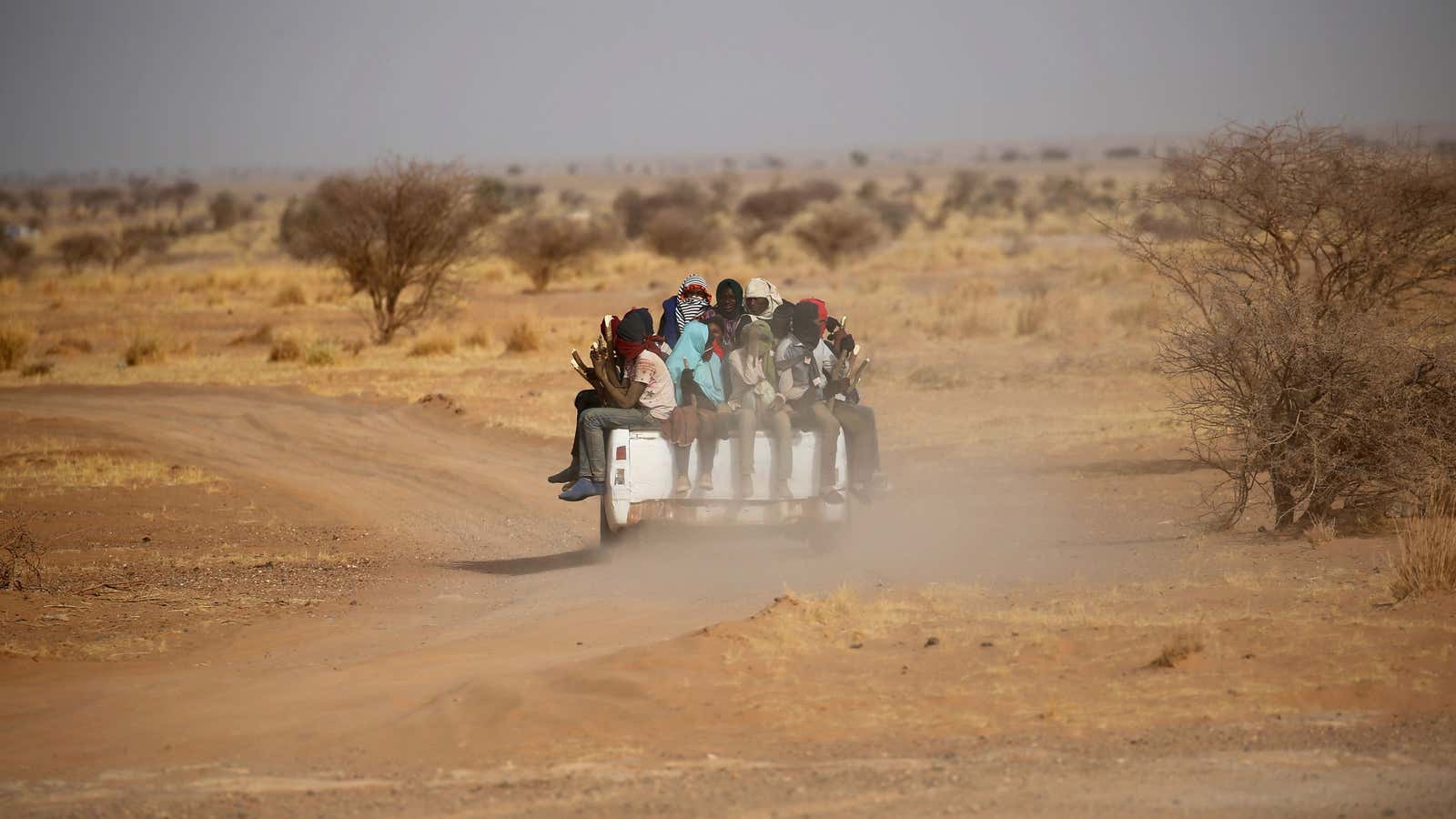 Migrants crossing the Sahara desert into Libya ride on the back of a pickup truck outside Agadez, Niger, May 9, 2016. Picture taken May 9,…