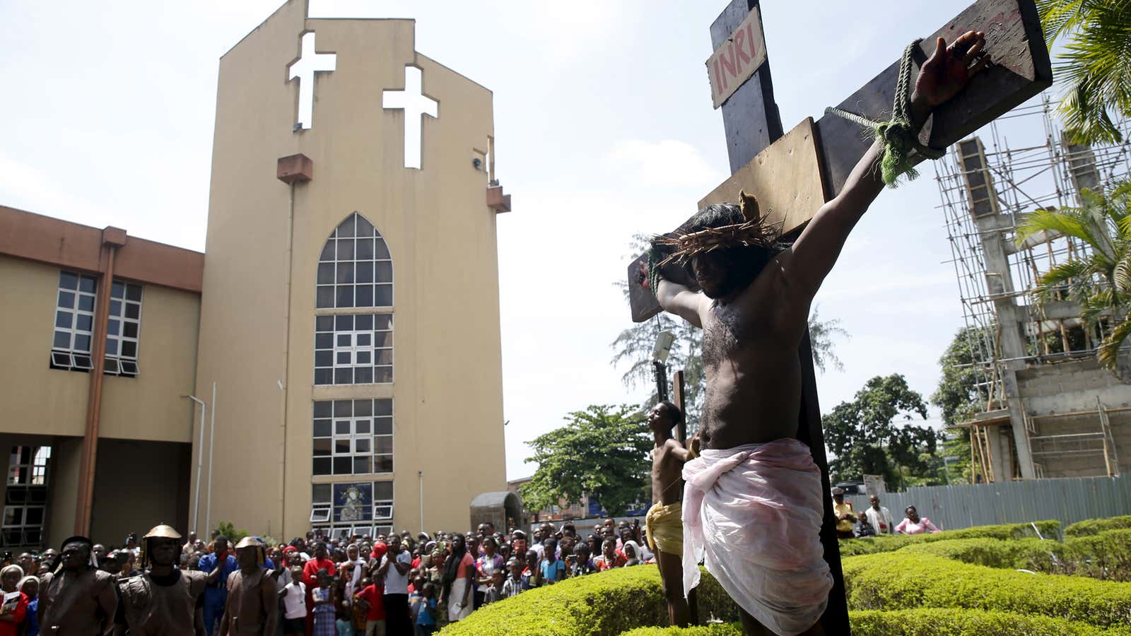 A man, portraying Jesus Christ, takes part in a re-enactment of the crucifixion of Jesus Christ on Good Friday along a road near St. Leo’s…