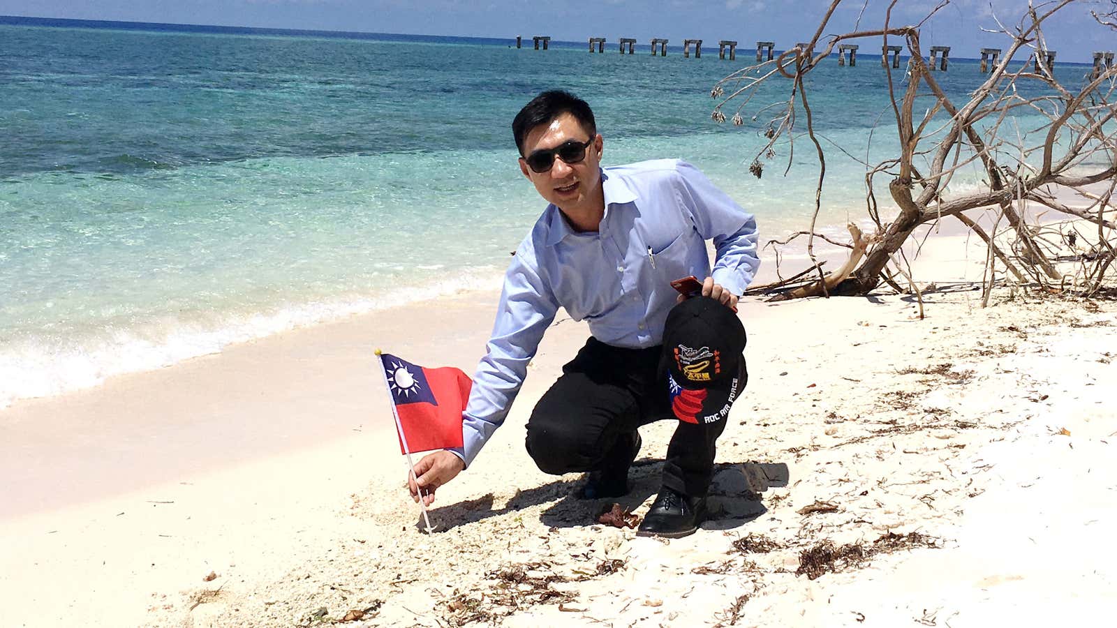 Taiwanese lawmaker Chiang Chi-chen plants the national flag on Taiping Island on July 20, 2016.