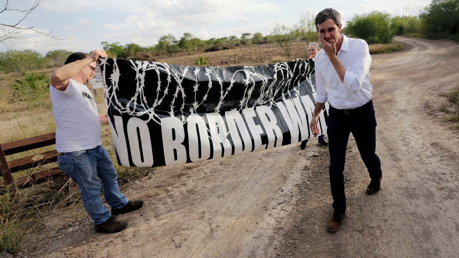 A protestor holds a “No Border Wall” banner while Beto O’Rourke visited the National Butterfly Center.