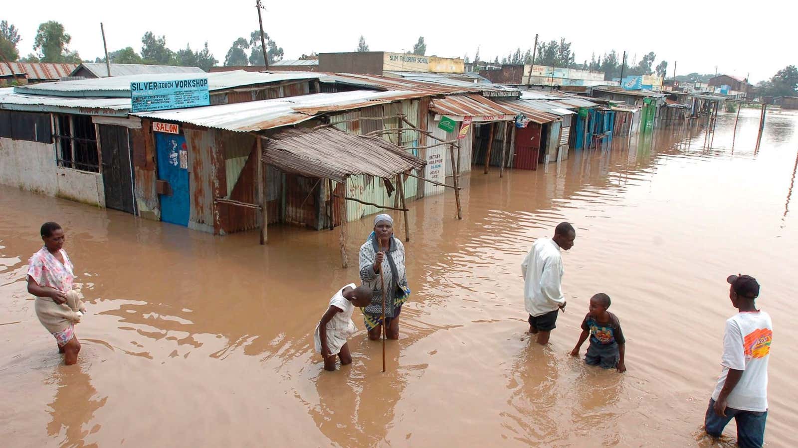 Villagers go about their business in a flooded market center in Kisumu, about 400 kilometers west of the capital Nairobi in Kenya.
