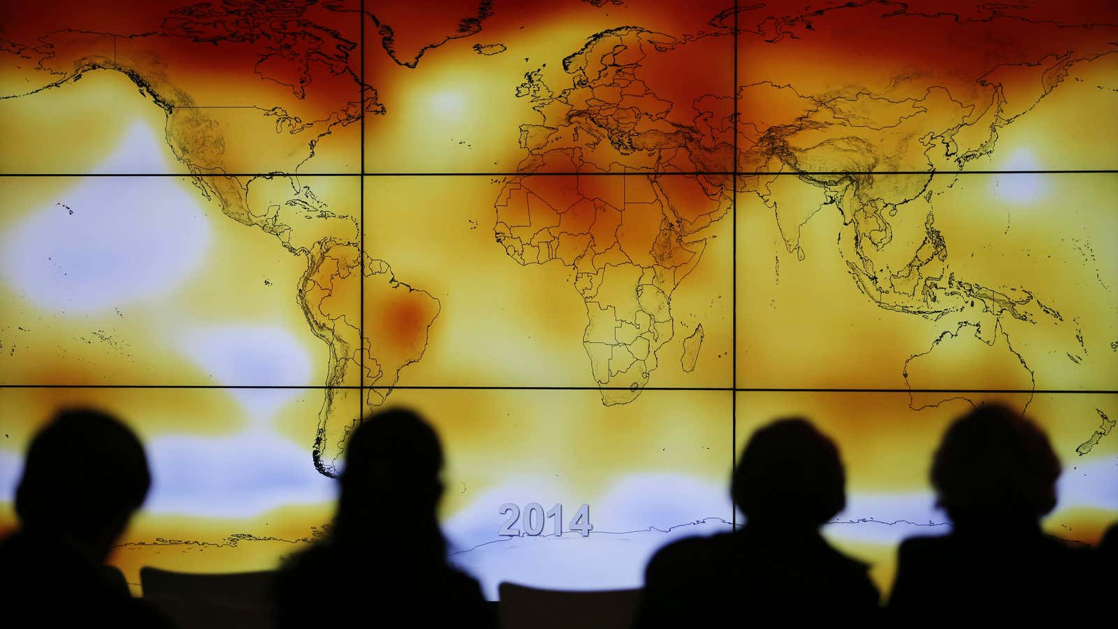 COP21 participants look at a screen showing a world map with climate anomalies during the World Climate Change Conference 2015 (COP21)