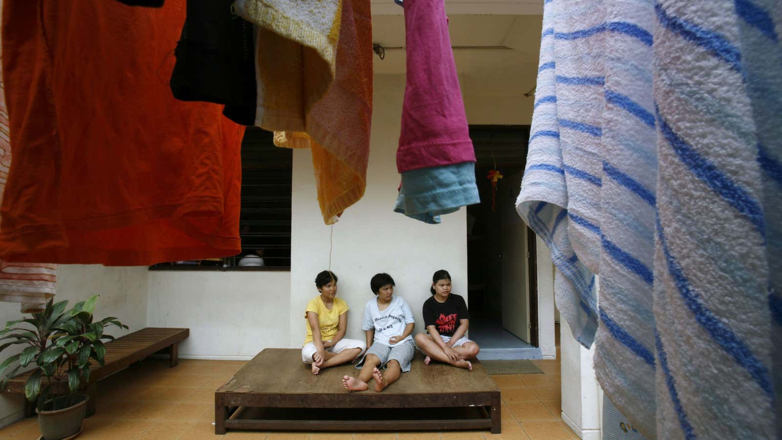 Indonesian women sit outside a shelter for abused domestic workers in Kuala Lumpur.