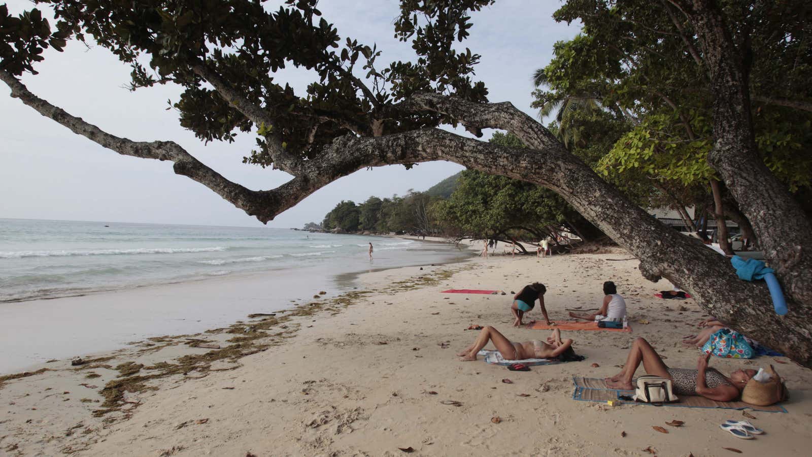Tourists sunbath on the beach of Beau Vallon in the Seychelles Island.