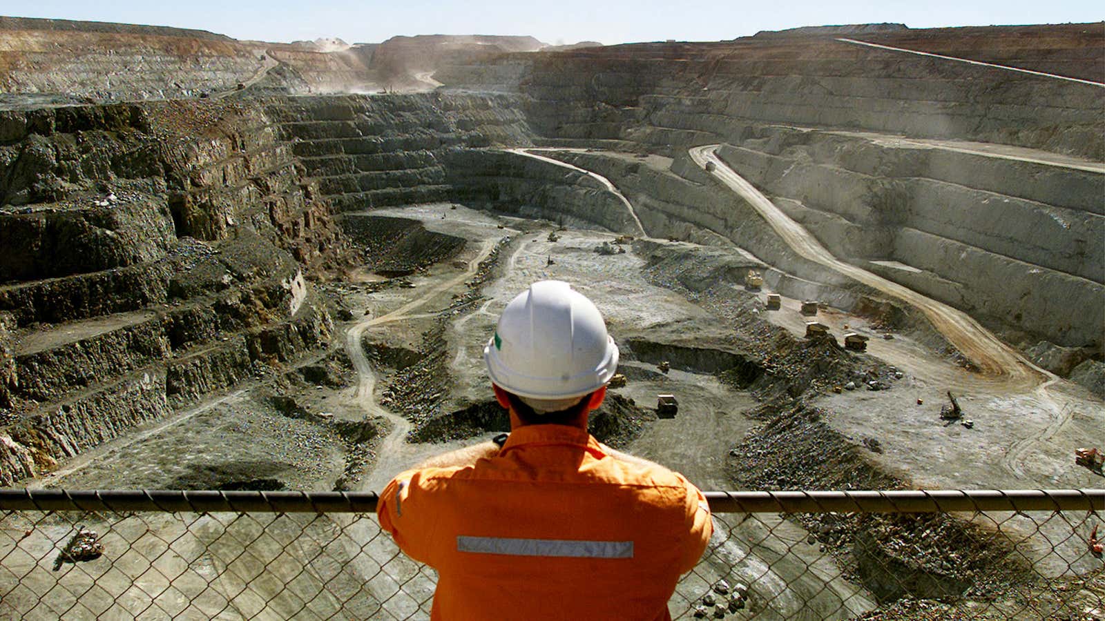 A miner looks across the largest open pit gold mine in Australia called the Fimiston Open Pit, also known as the Super Pit, in the…
