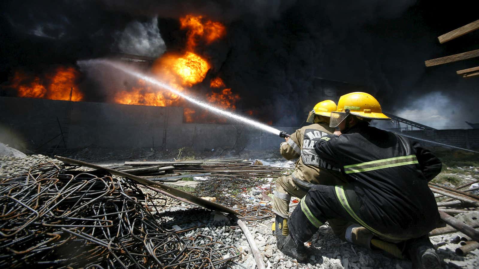 Firefighters attempt to control a fire at a factory Valenzuela City, north of Manila, on May 13.