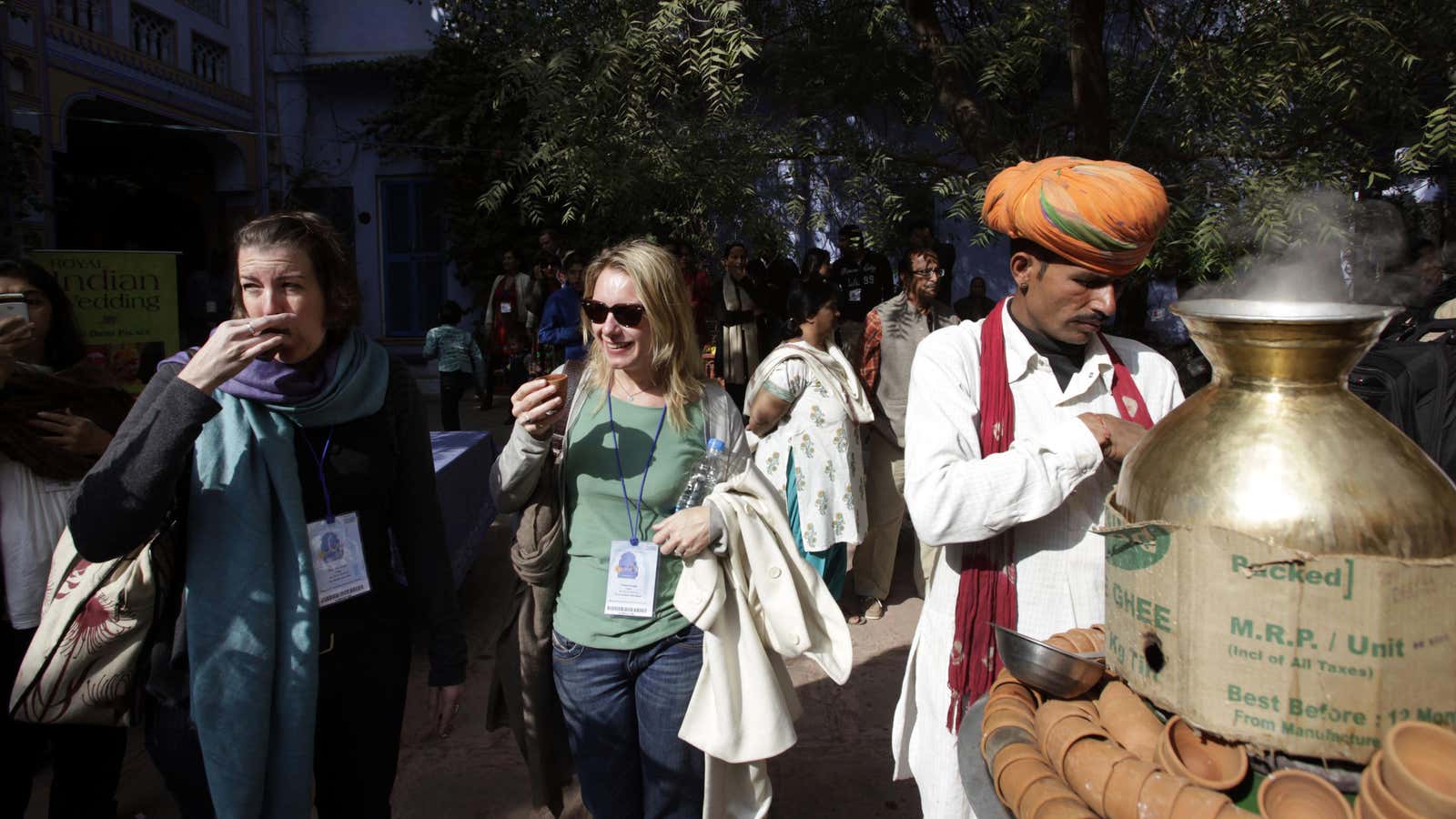 Foreign delegates sip tea in earthen mugs from a local tea vendor at the Jaipur Literature Festival.