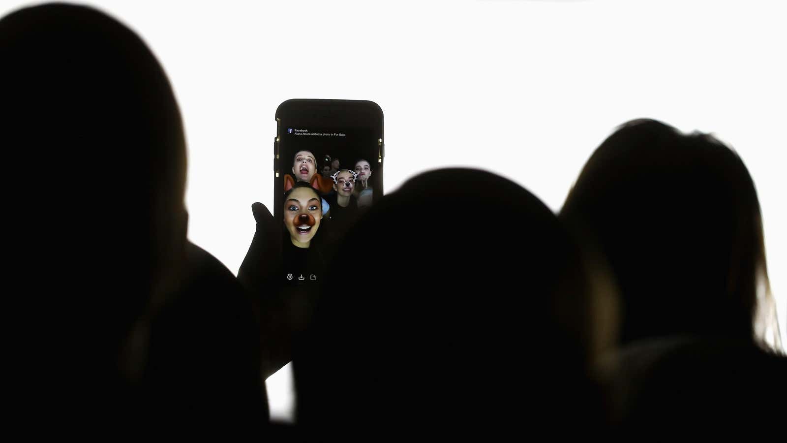 A group of users take an augmented reality-enhanced selfie on Snapchat. 