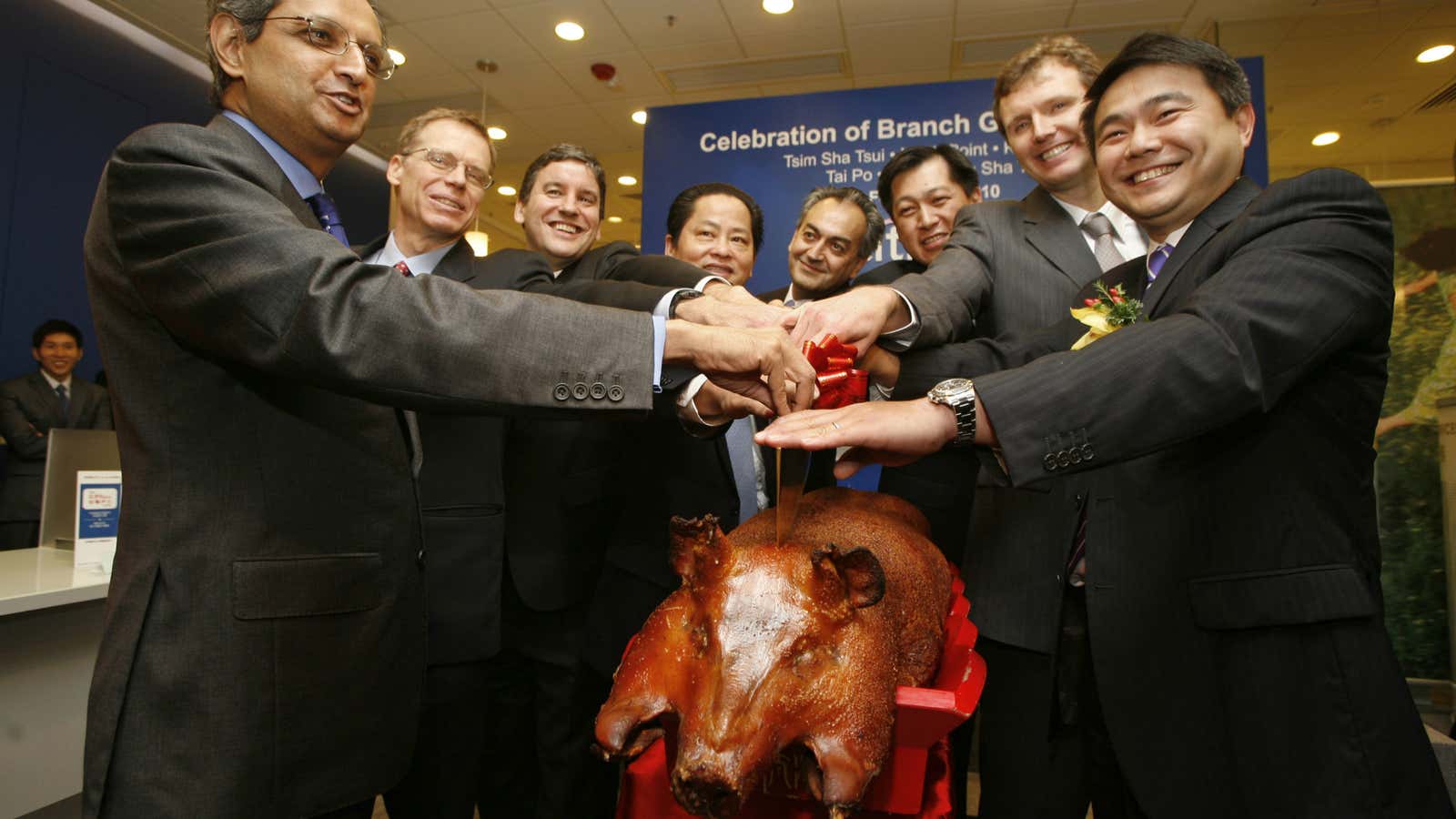 Citigroup executives, including Bird (second from right) celebrate the opening of a Hong Kong branch with a roast pig.