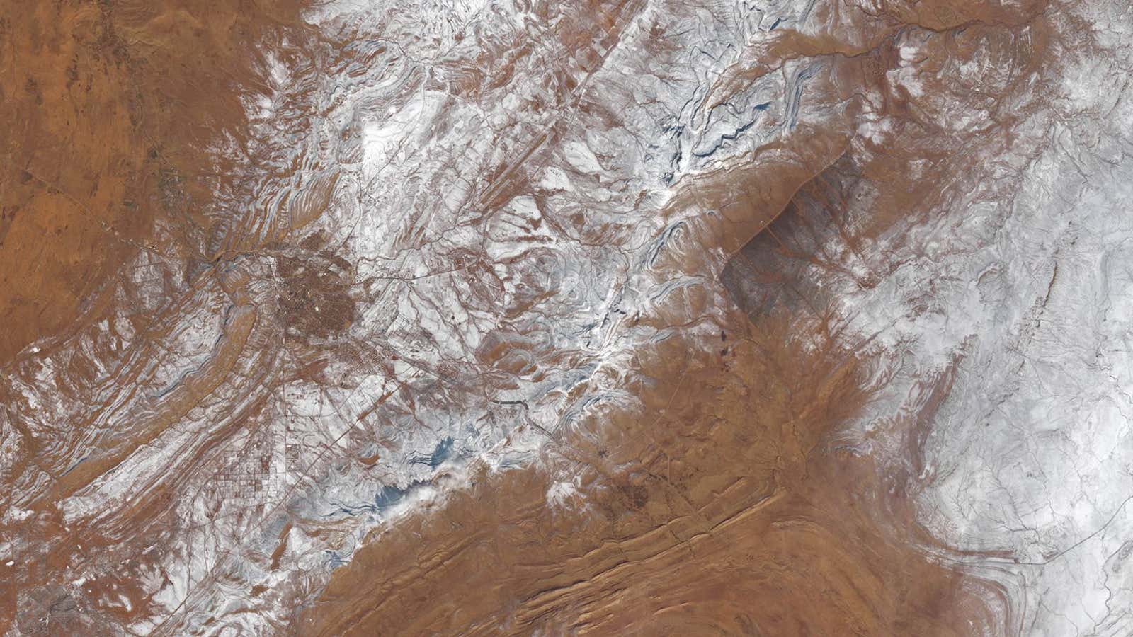 This Landsat image shows snow rising with the local elevation near Aïn Séfra in the Sahara desert.