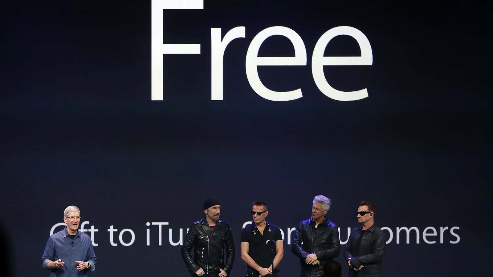 Apple CEO Tim Cook (L) stands with Irish rock band U2 as he speaks during an Apple event announcing the iPhone 6 and the Apple…