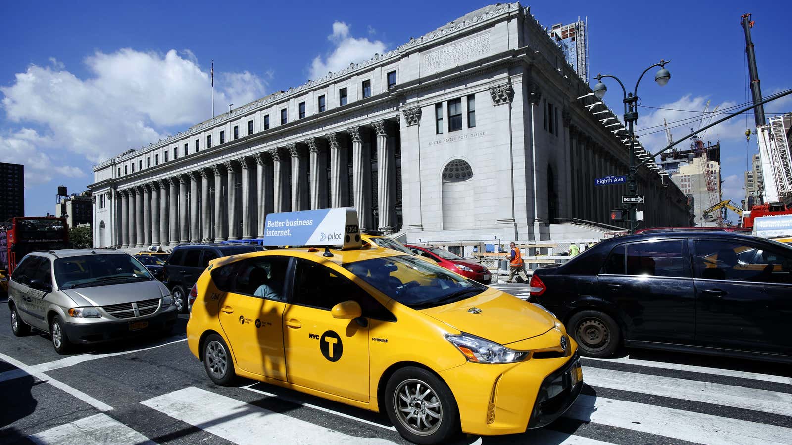 A taxi driver drives past the James A Farley post office building in New York.