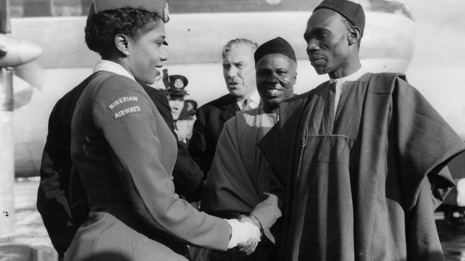 The first Nigerian prime minister, Abubakar Tafawa Balewa, greets an air stewardess after the inaugural flight of the WAAC (West African Airline Company) on Oct 1, 1958.