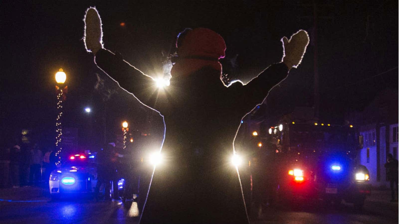 A protester blocks police cars in Ferguson, Missouri on Nov. 25.