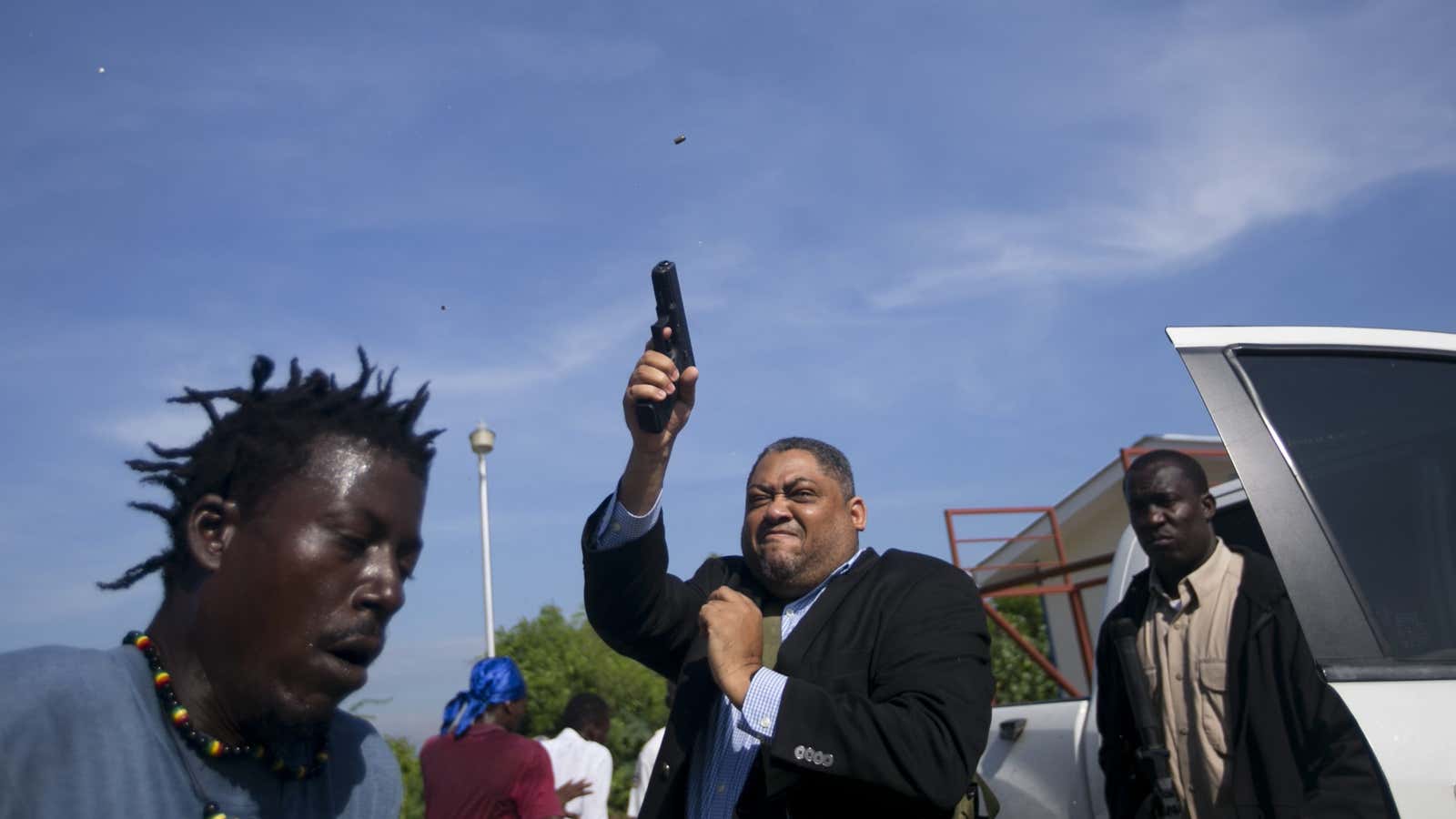 Ruling party Senator Ralph Fethiere fires his gun outside Parliament in Port-au-Prince.
