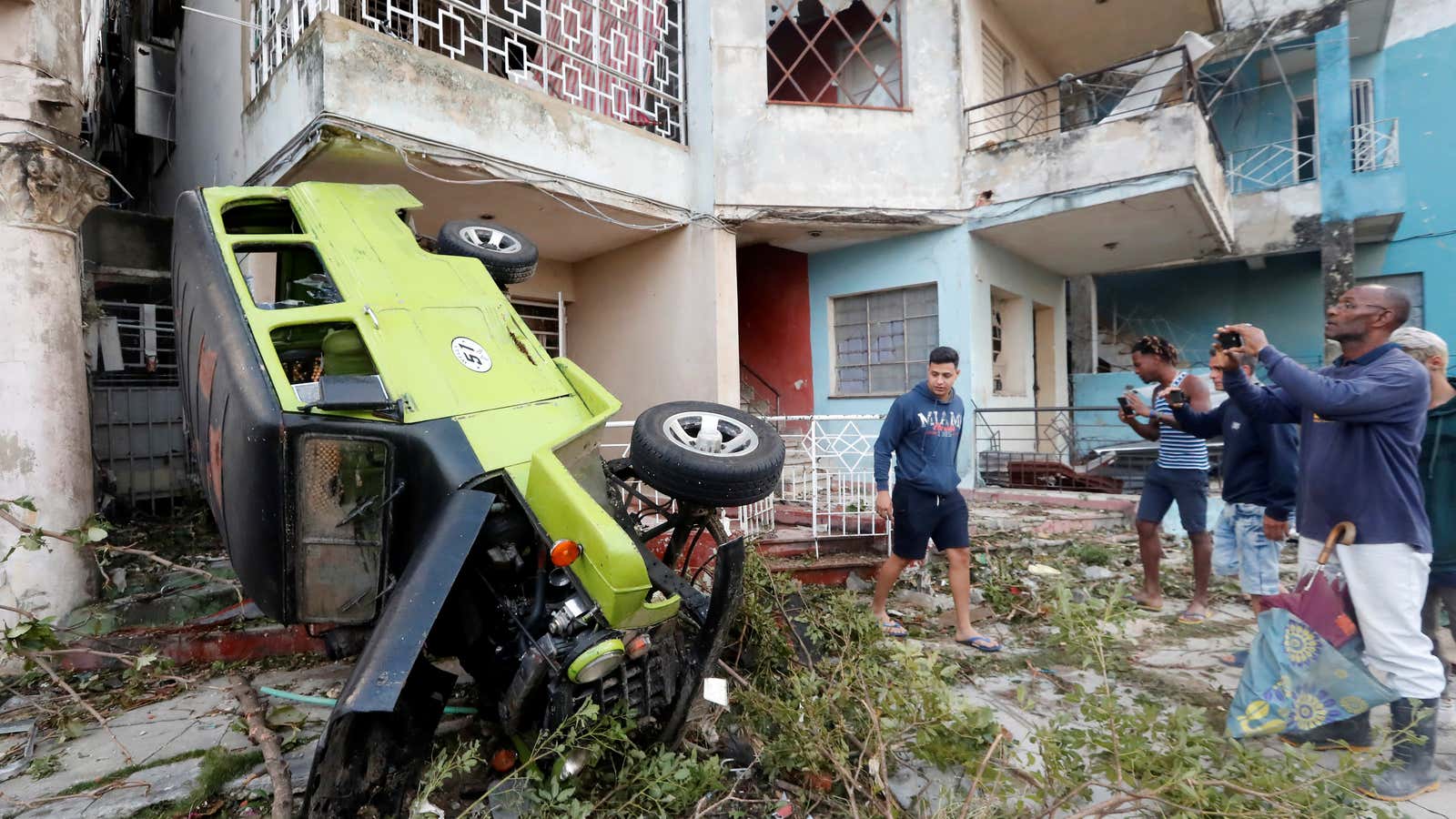 Residents look at a vehicle toppled by a tornado in Havana.