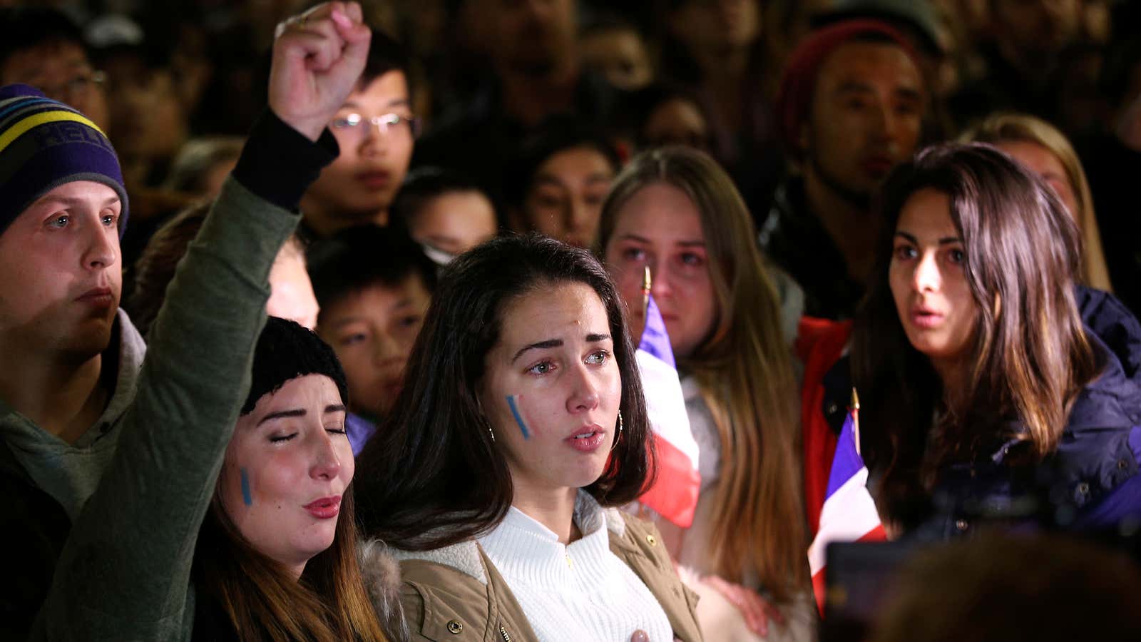 People gather and sing the French national anthem at a vigil in a tribute to the victims of the Bastille Day attack, in Sydney, Australia.